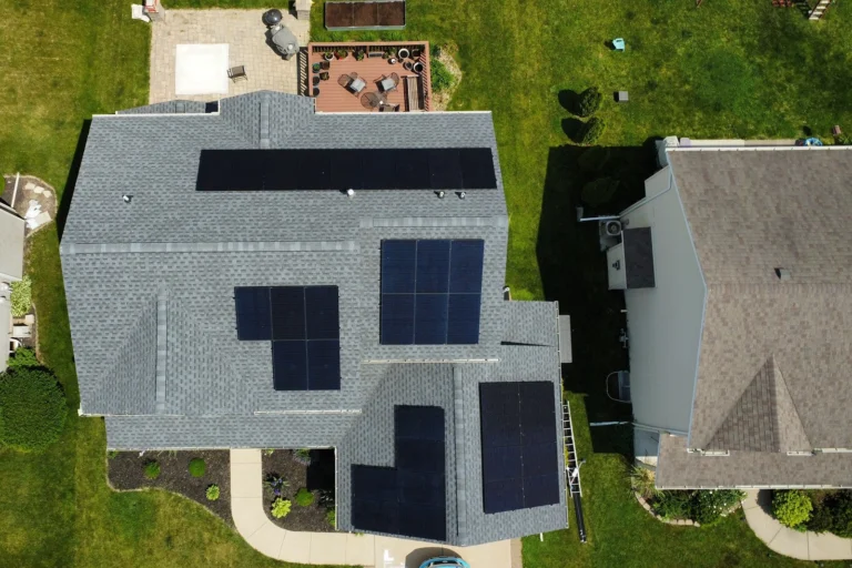 Top-down drone view of a comprehensive solar roofing system featuring multiple panel arrays installed by ROOF TIGER.