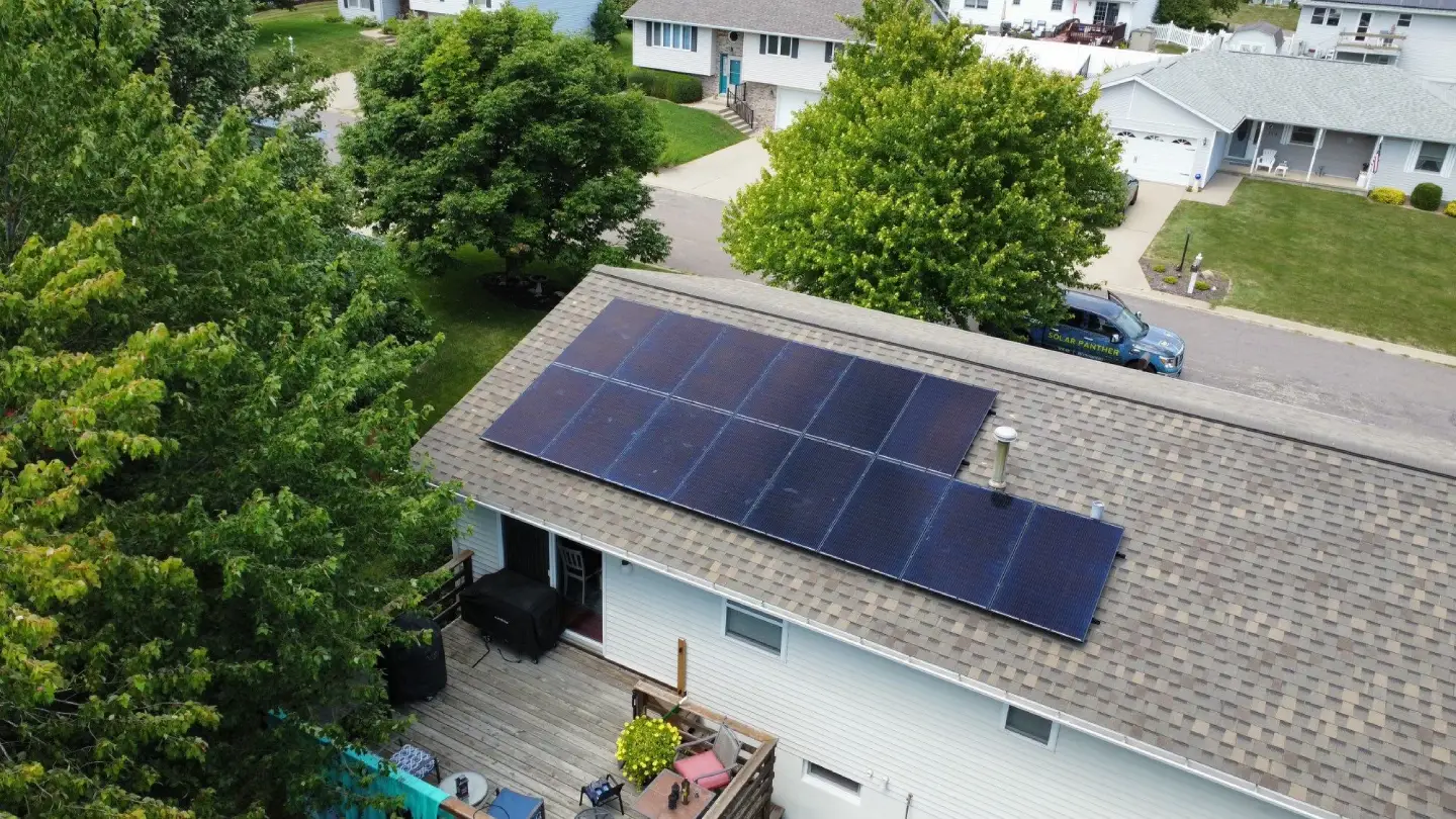 A clean shingle roof equipped with a sleek solar panel array and a wooden rear deck, representing the comprehensive energy-efficient roofing services Illinois homeowners.