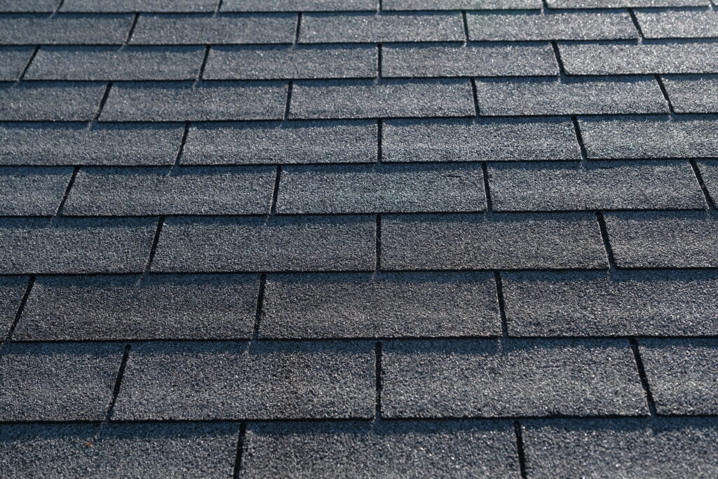 Detailed view showing the flat, uniform profile of 3-tab shingles compared to the thicker, premium look of architectural shingles vs 3 tab options for residential roofing.