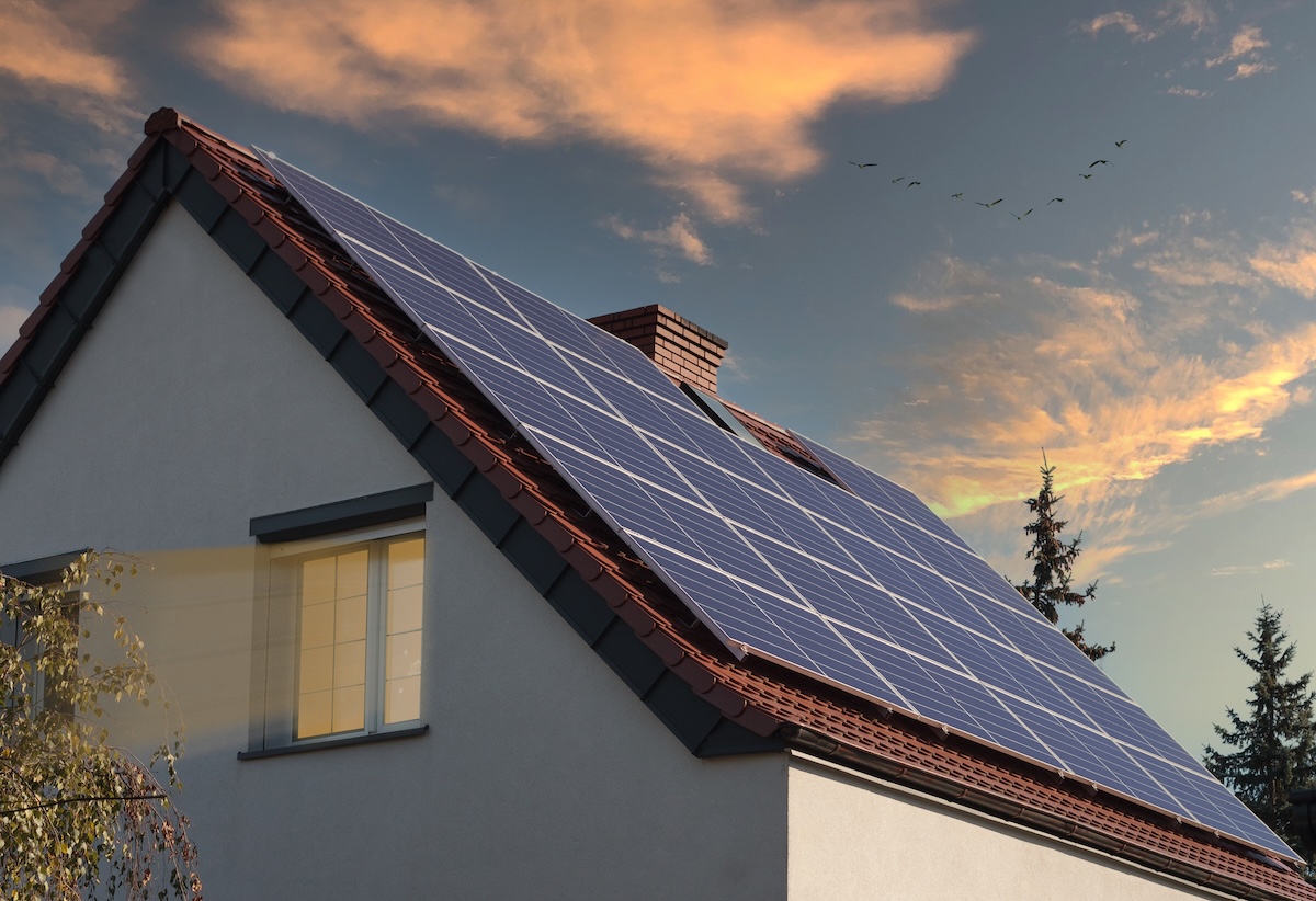 Beautiful new houses with solar panels in a suburban area. Evening view.