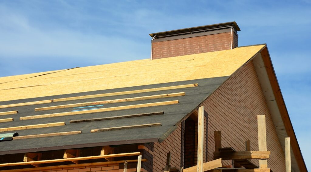 roof decking Roofing construction on the stage of roofing underlayment installation on the roof deck, roof sheathing.