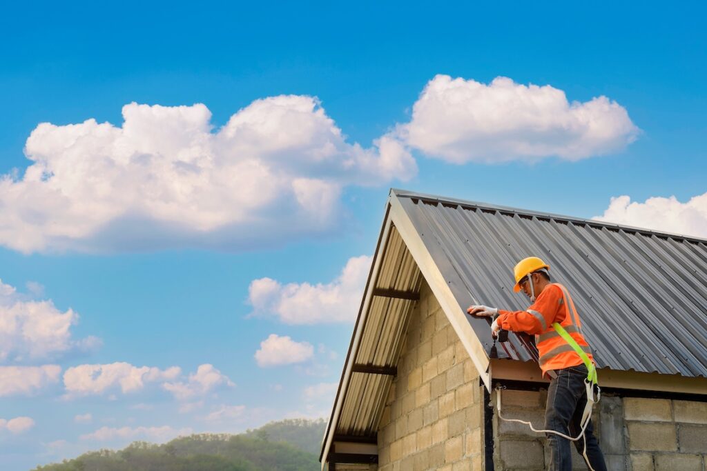 metal roof repair Roofer Construction worker install new roof,Roofing tools,Electric drill used on new roofs with Metal Sheet.