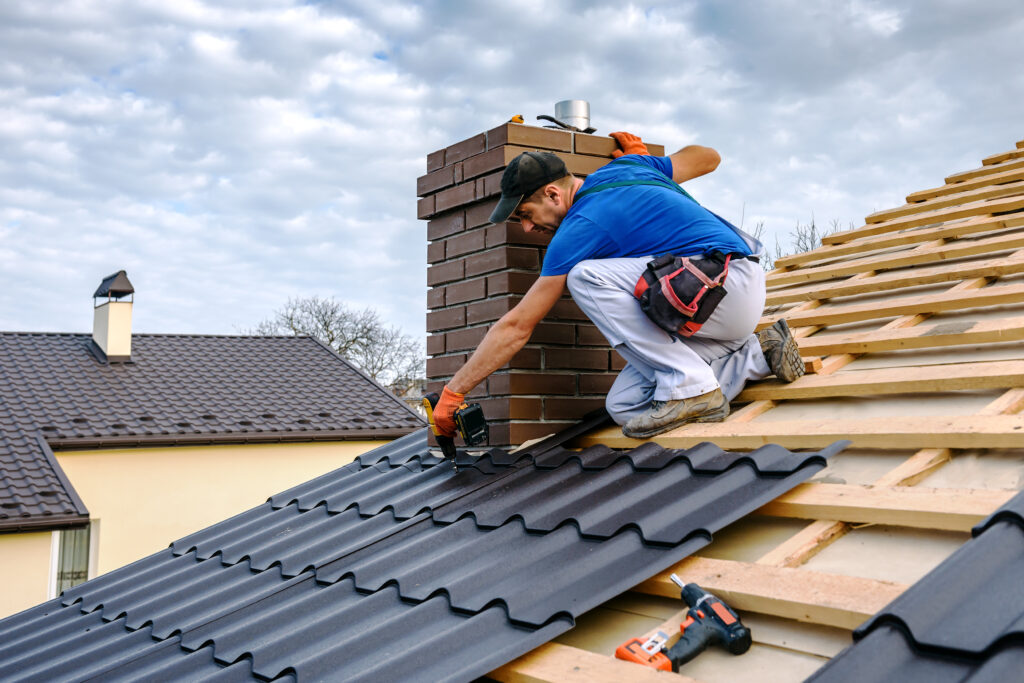 metal roof repair a professional master (roofer) with electric screwdriver covers repairs the roof