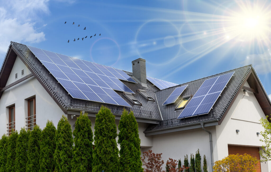 how to clean solar panels on roof Solar panels on a gable roof. Beautiful, large modern house and solar energy. Rays of the sun.