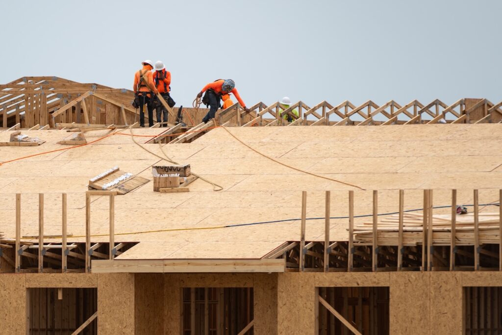 roof decking Preparing the roof deck for OSB installation. Cutting OSB sheets for roof. roofing. Roof deck for installation. Roof frame for beam installation. Male roofer carpenter working on roofs structure