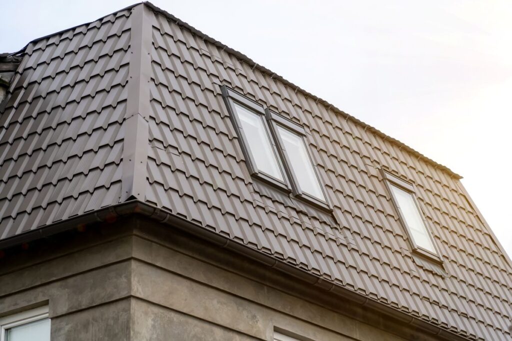 Mansard roof with metal coating of residential building with windows